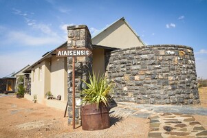 Un edificio con pared de piedra y un cartel que dice "AIAISENSIS".
