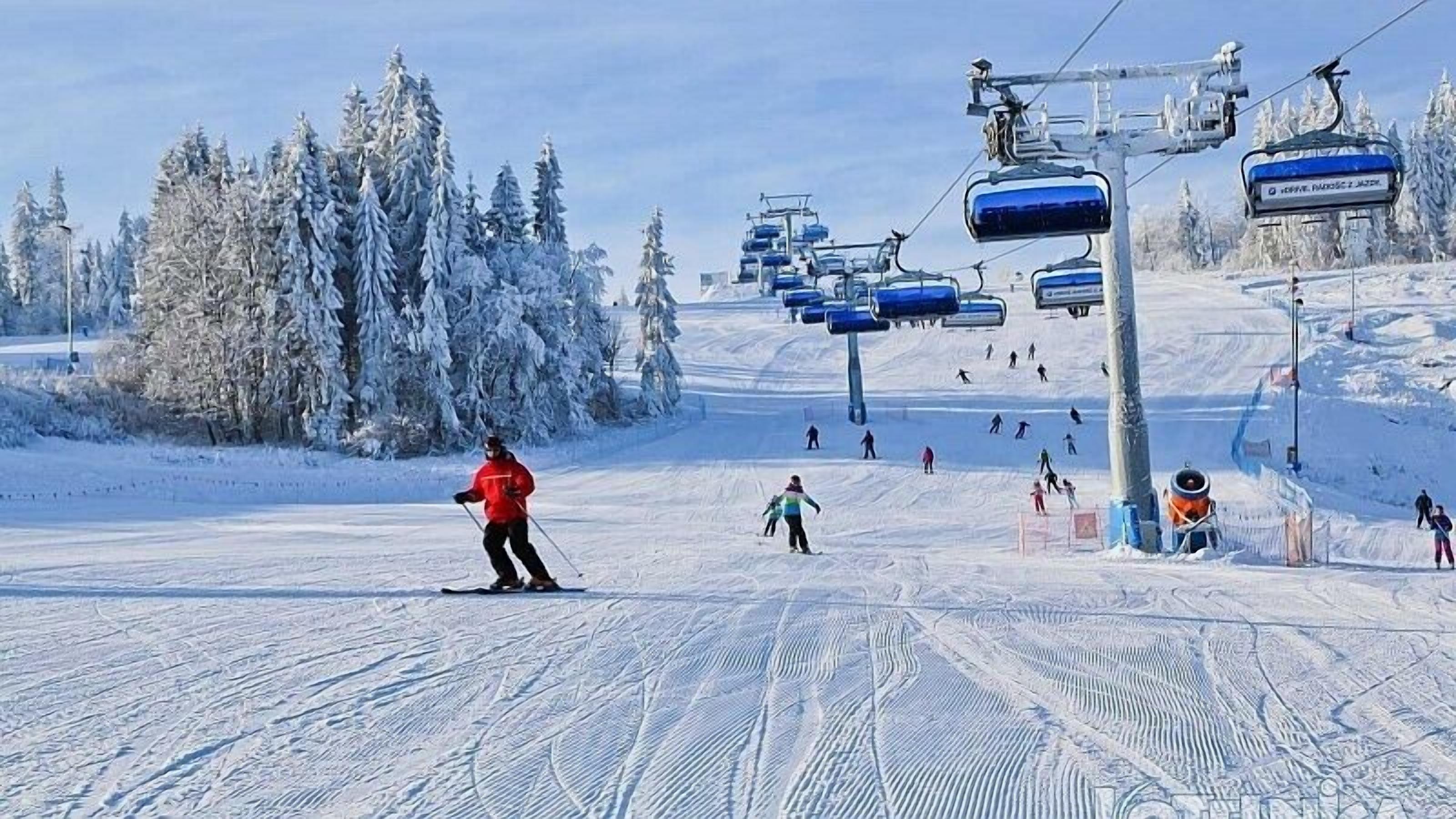 A ski slope with skiers and a ski lift.