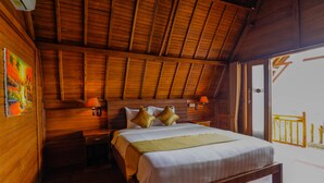 Una habitación de madera con cama, mesitas de noche y un balcón con ventanal.