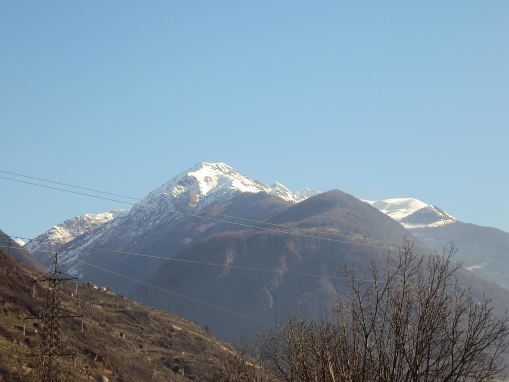 A mountain landscape with snow-capped peaks and power lines in the foreground.