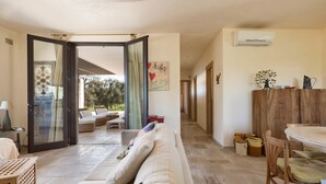 A spacious living area with a sofa, a dining table, and a kitchen area.