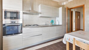 Une cuisine moderne équipée d’appareils électroménagers en acier inoxydable, d’un four encastré et d’une cuisinière à gaz.