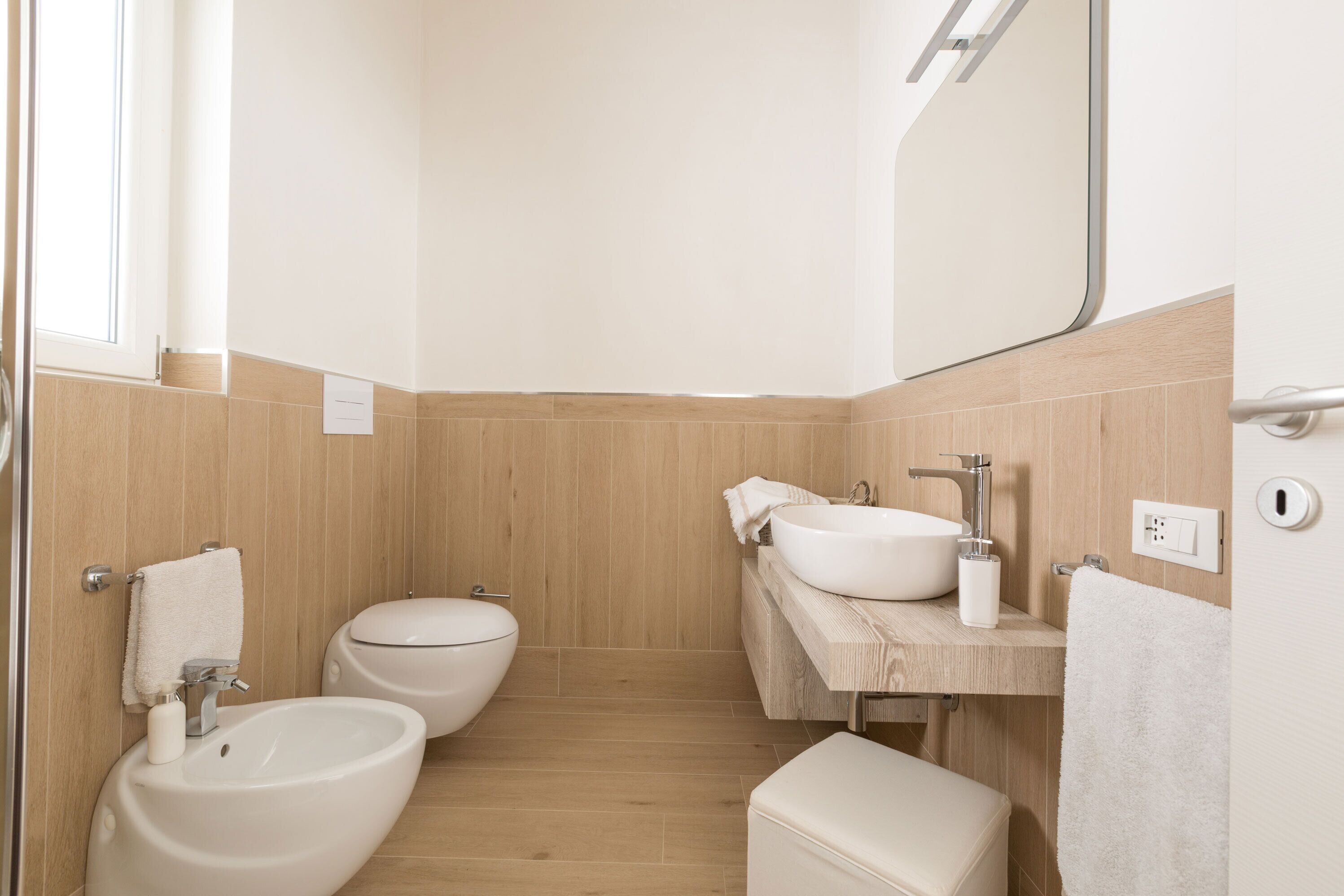 Un baño pequeño con bidé, inodoro y lavamanos.