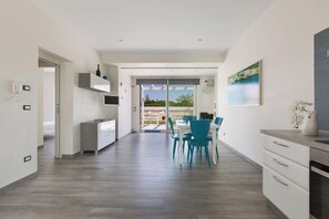 A modern kitchen with a dining area, a view to the outside, and a large window. - Villa Evi (Carovigno)