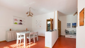 A bright living room with a dining area, a sofa, and a kitchen island. - Villa Scirocco (Porto Cesareo)