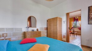 A bedroom with a bed, a wardrobe, a mirror, and a view of a balcony. - Villetta Baron Beach (Porto Cesareo)