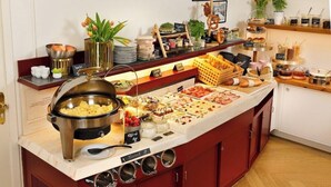 En buffé med ett varierat utbud av mat, en kaffestation och dekorativa växter.