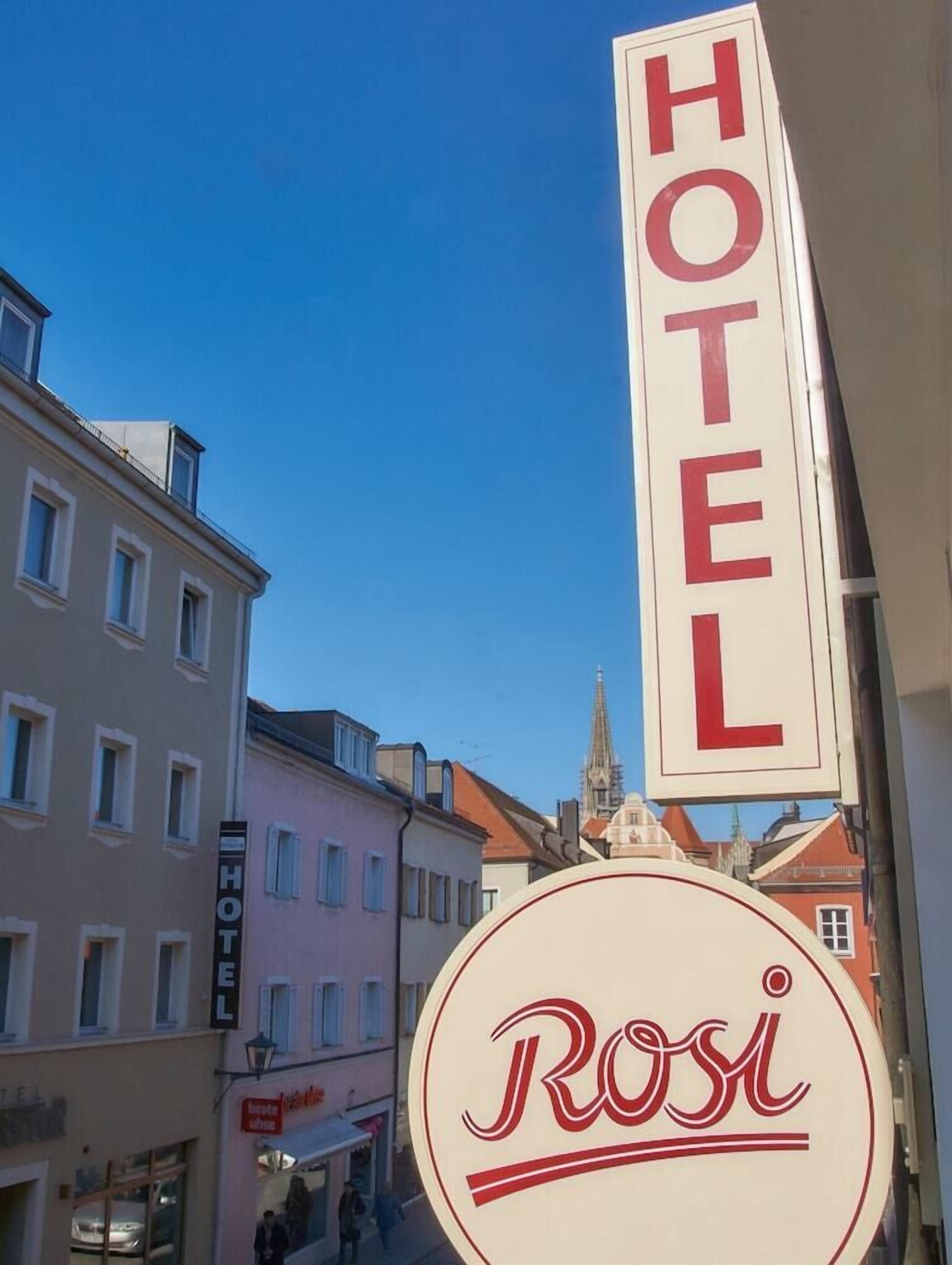 Segnaletica di un hotel con la scritta 'HOTEL' e un cartello circolare con il nome 'Rosi'.