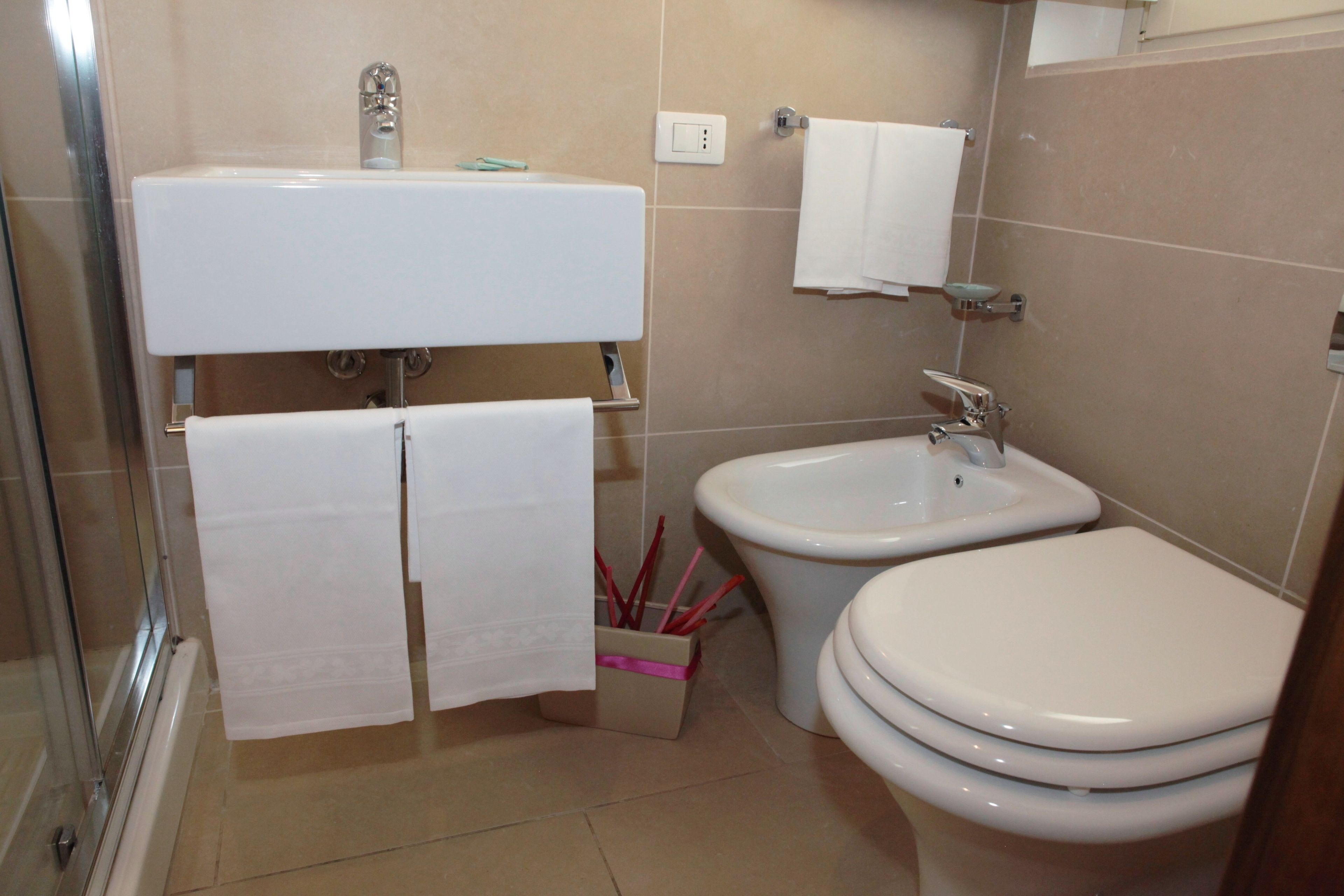 A bathroom with a sink, bidet, and toilet.
