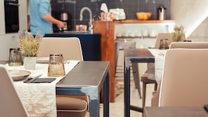 Un interior de restaurante moderno con barra, mesas y sillas, y un menú en una pizarra.