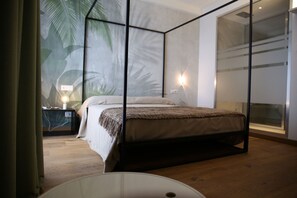 Een moderne slaapkamer met een bed, een nachtkastje, een wandlamp en een groot raam.
