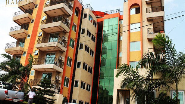 Un immeuble à plusieurs étages doté de balcons, de climatiseurs et d’une enseigne indiquant « HAINPA ».