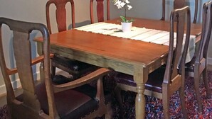 A dining room with a wooden table, six chairs, and a vase with flowers. - Bright, Spacious 2 Bedroom Apartment in Stockbridge (Edinburgh)