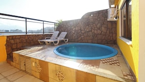 A rooftop pool area with a stone wall, two lounge chairs, and a tiled deck. - MZapartments Raul Penthouse 03 (Rio de Janeiro)