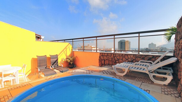 A rooftop pool with lounge chairs, a table, and a view of the cityscape. - MZapartments Raul Penthouse 03 (Rio de Janeiro)