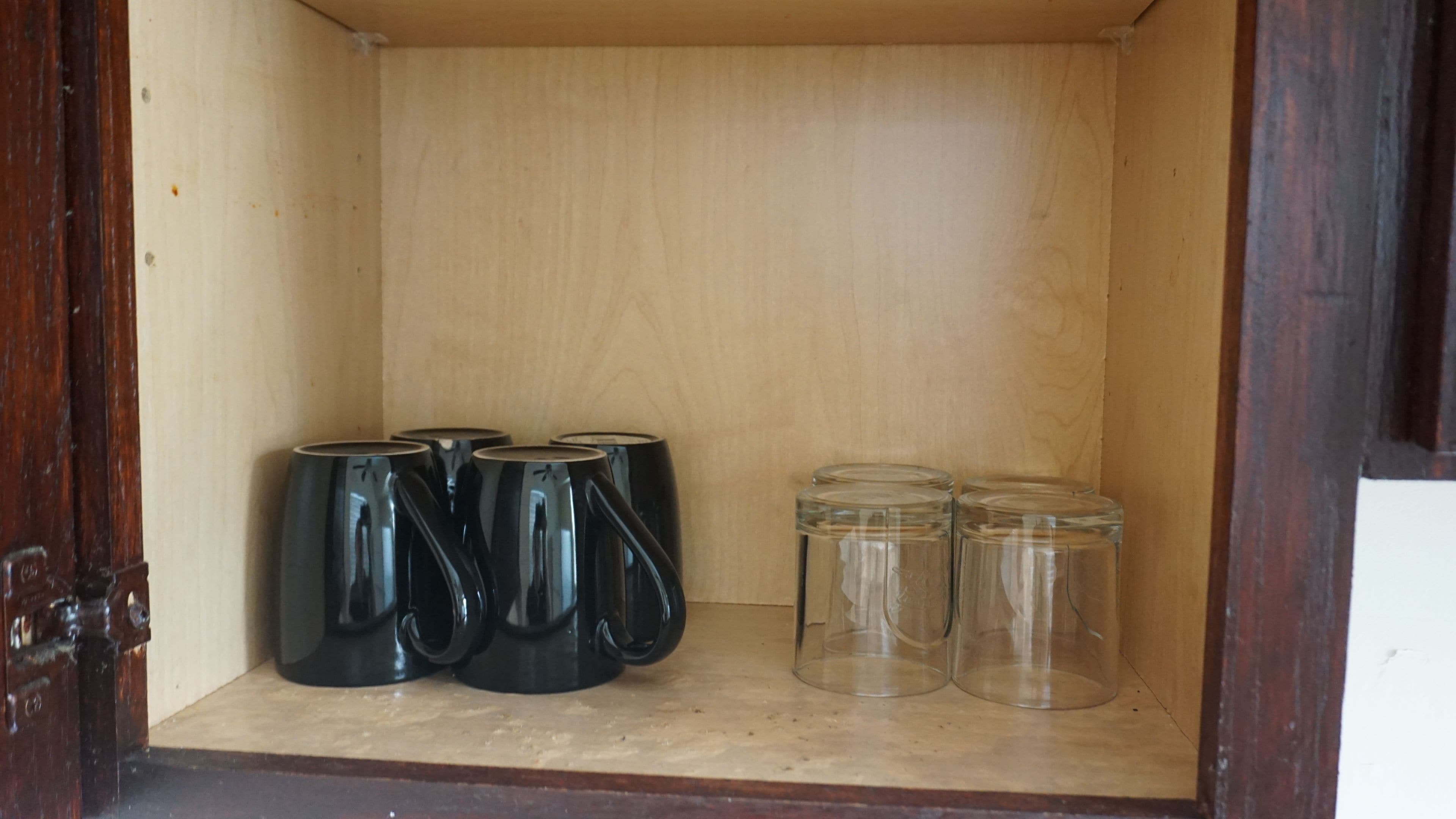 Ett träskåp med behållare i svart och genomskinligt glas.