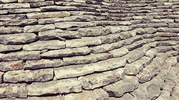 A stone wall with a curved design, likely part of a historical or architectural structure.
