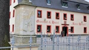 A building with a facade featuring a sign that reads "Gasthof & Hotel Roter Hirsch". - Pension Gasthof und Hotel Roter Hirsch (Claussnitz)