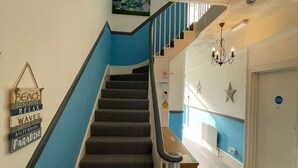 A staircase with a blue accent wall and a sign with various phrases. - Bon-ami (Lowestoft)