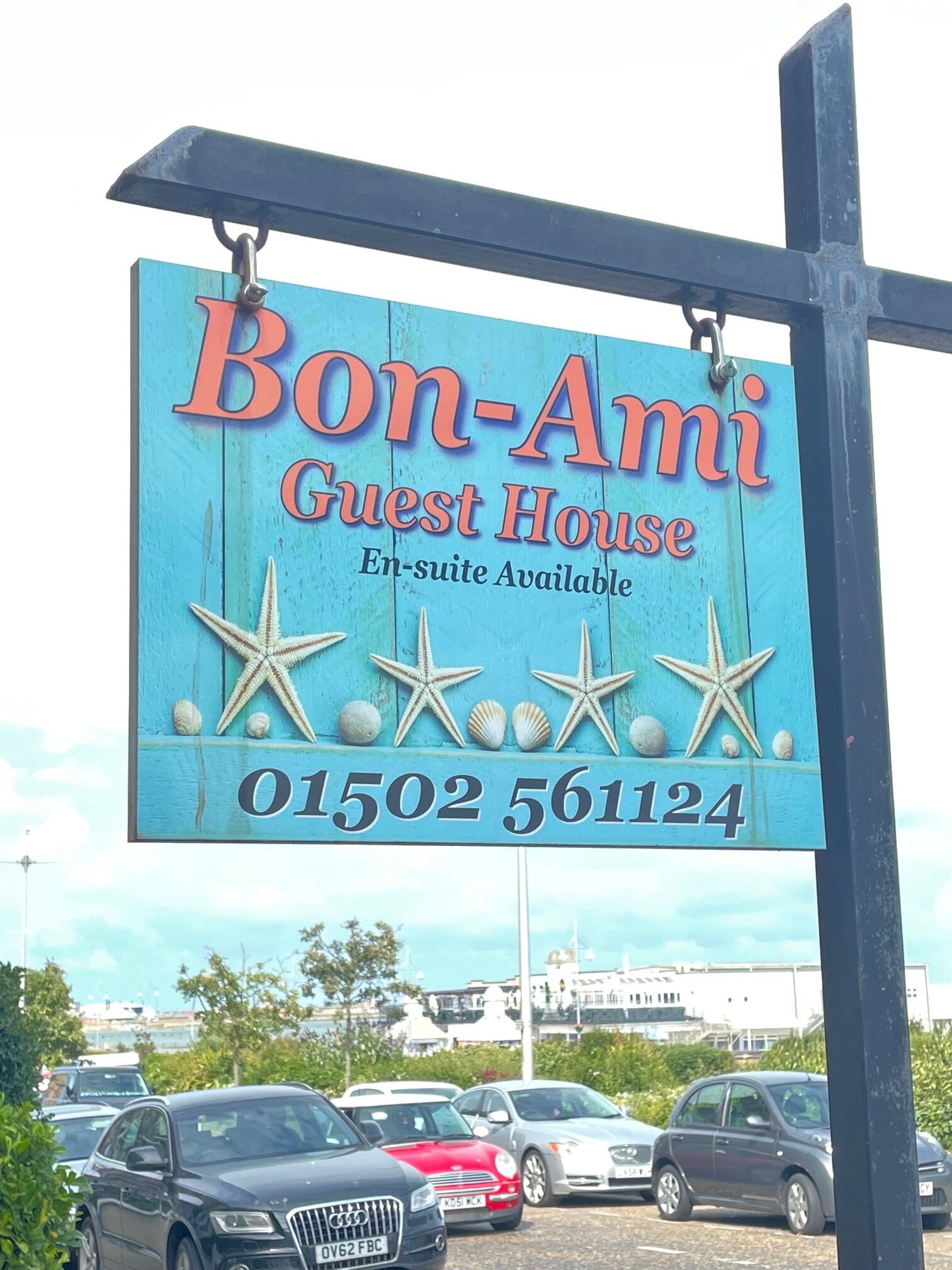 A sign for Bon-Ami Guest House with a contact number.