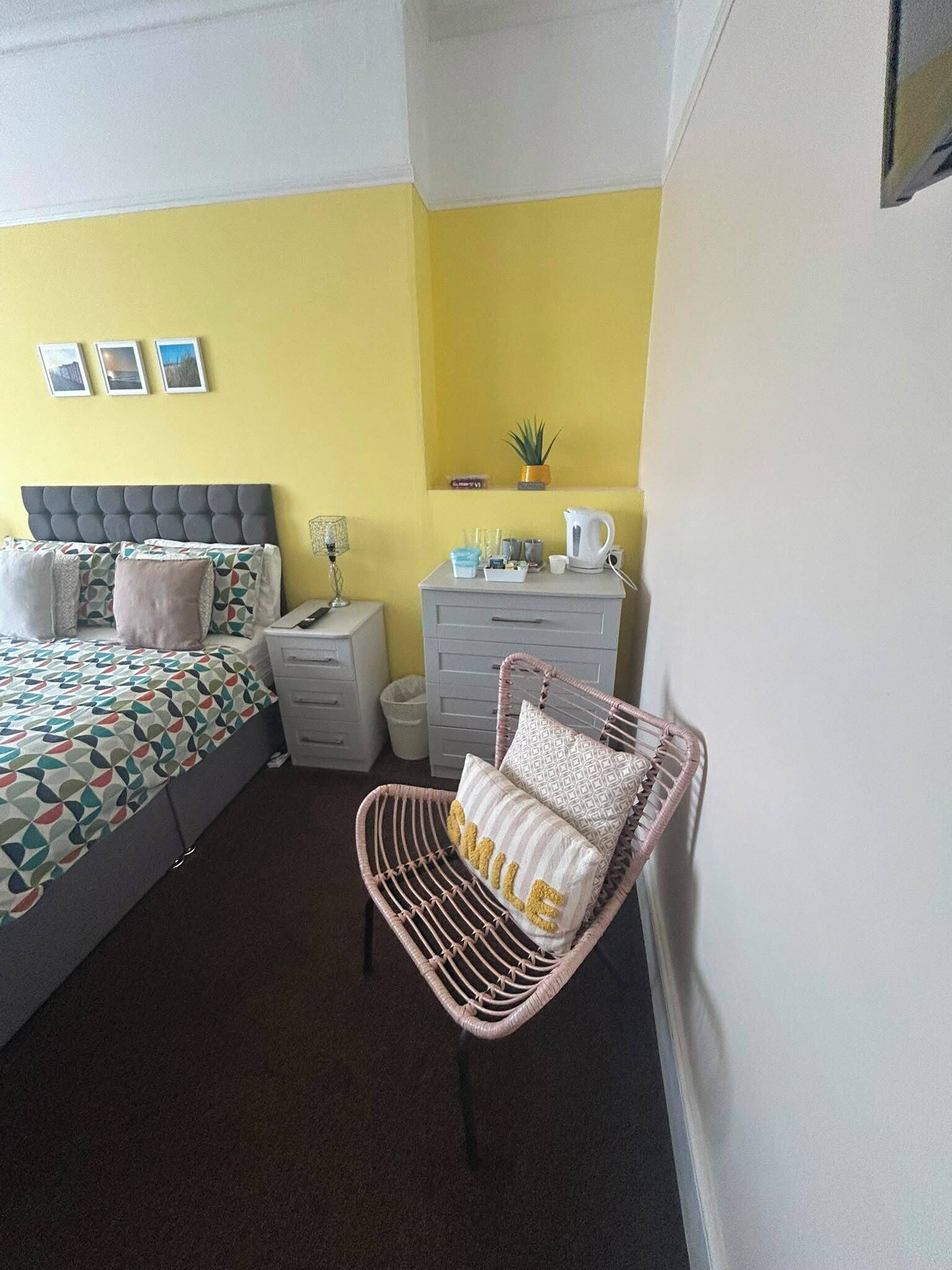 A bedroom with a bed, bedside tables, a chair, and a dresser.