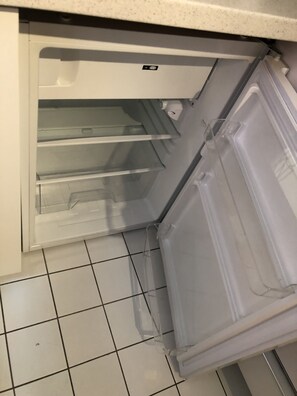 An open refrigerator with clear shelves and a control panel. - Altstadtflair (Regensburg)