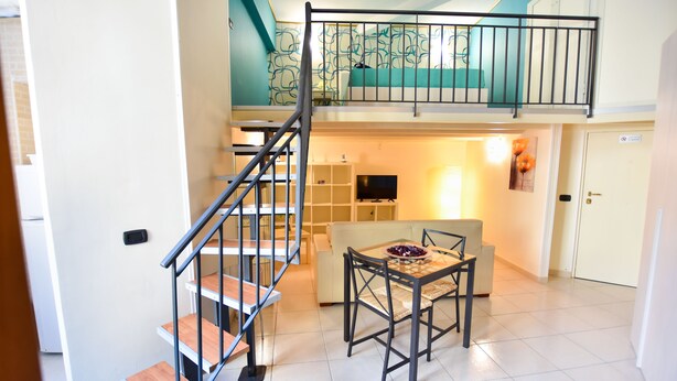A multi-level apartment with a staircase, a dining area, a living room, and a kitchen. - B&B Mary Flower (Naples)