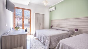 Une chambre d’hôtel avec un lit, un bureau, une télévision et un balcon donnant sur une montagne.
