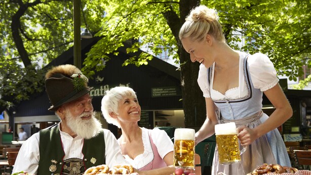 A table with food and drinks, likely in an outdoor setting with trees in the background. - Newstyle (Regensburg)