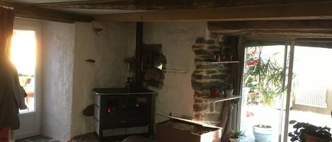 Un interior rústico con chimenea de piedra, un sofá de cuero y una pequeña mesa con adornos.