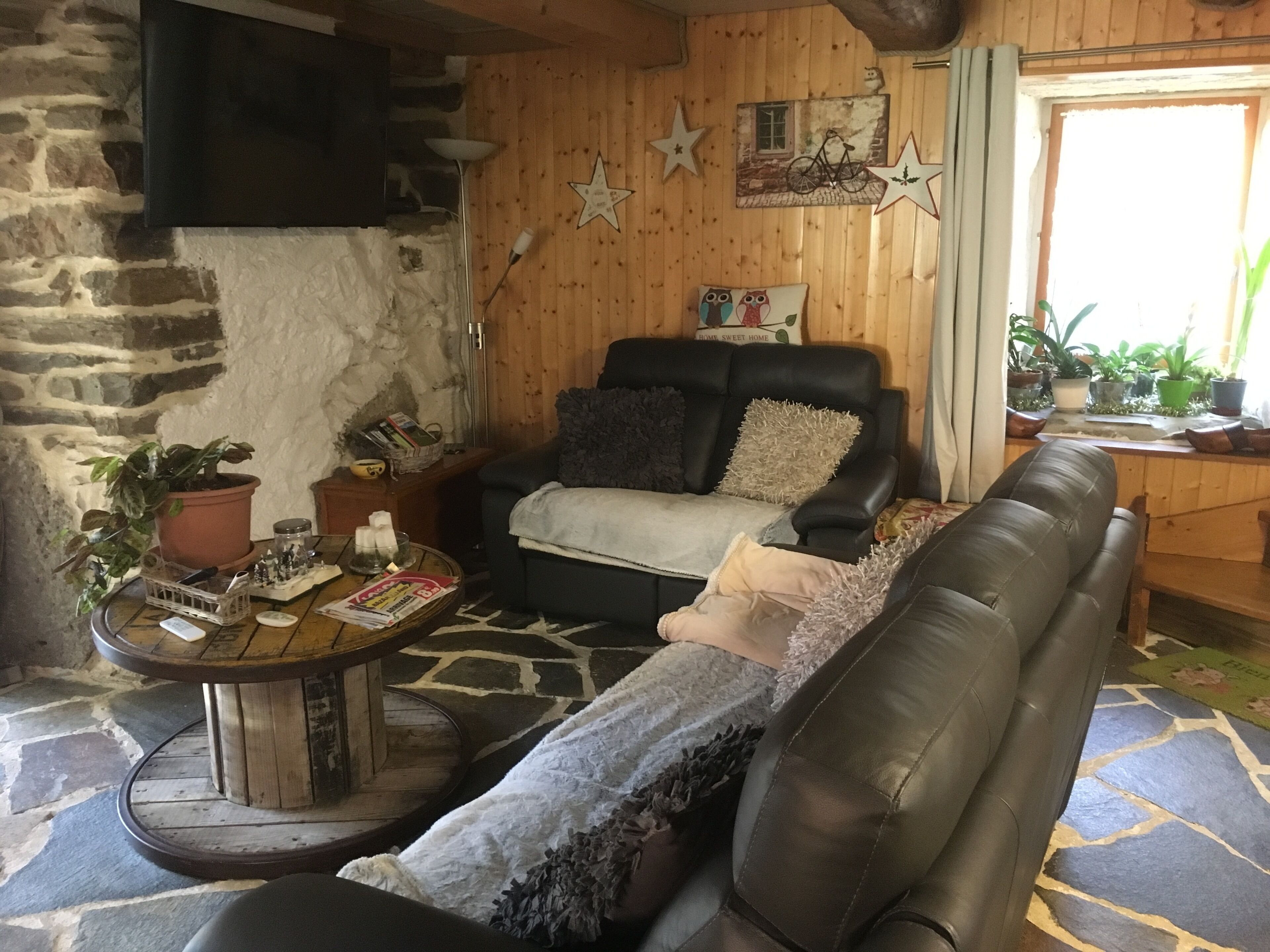 A cozy living room with a fireplace, a leather sofa, a coffee table, and various decorative items.