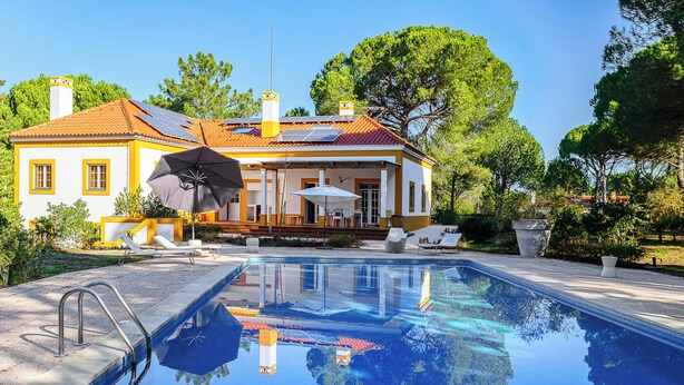Una piscina con vista despejada a una casa al fondo.