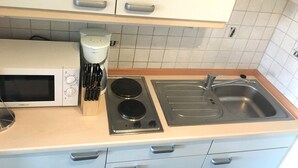 Keittiössä on mikroaaltouuni, kahvinkeitin, liesi ja pesuallas.