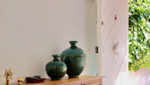A wooden console table with two green vases and a small ship model. - VILLA LOS REMOS SEAVIEW (Mojácar)