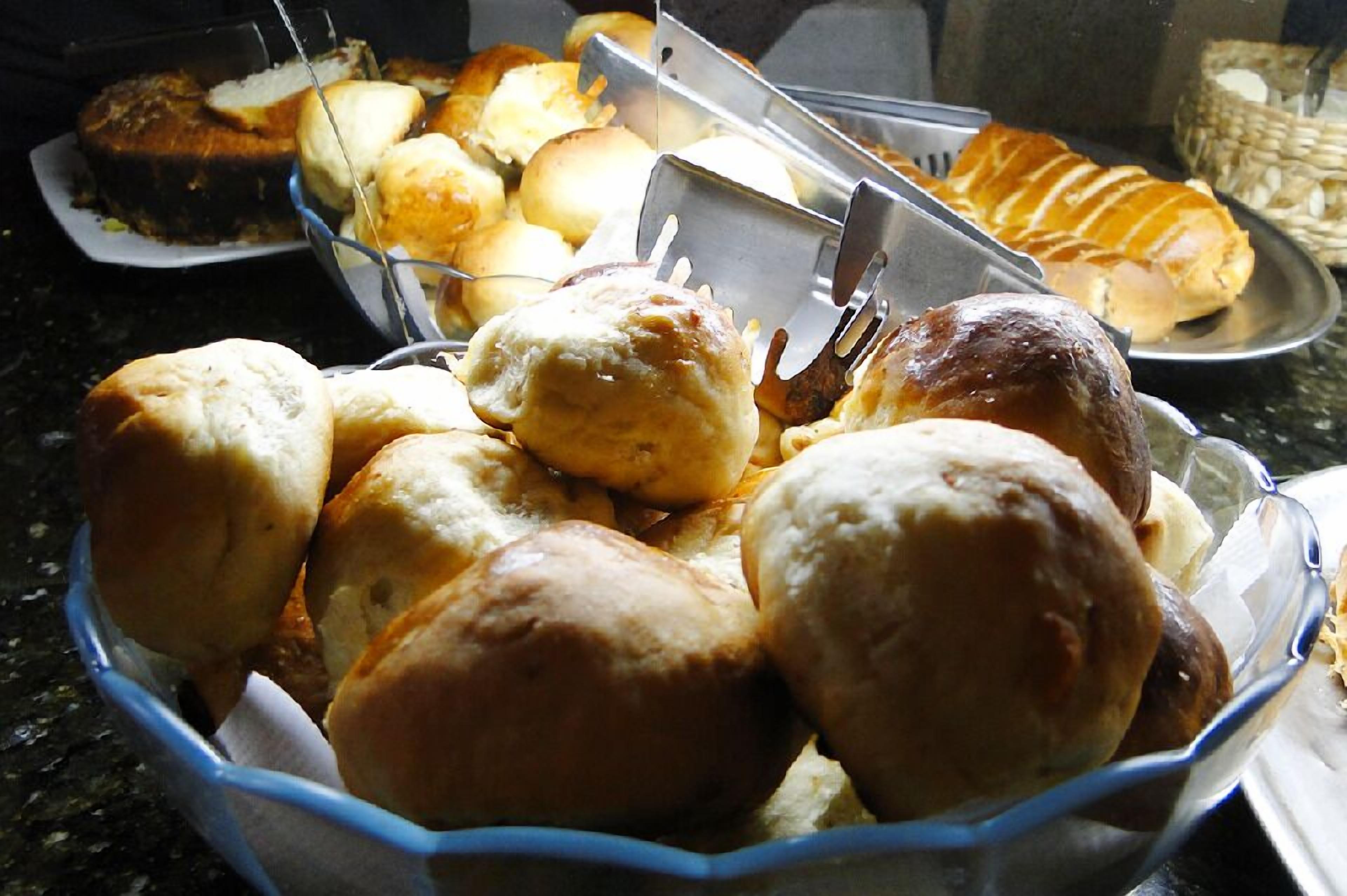 A tray of assorted baked goods, including rolls and pastries, on a countertop.