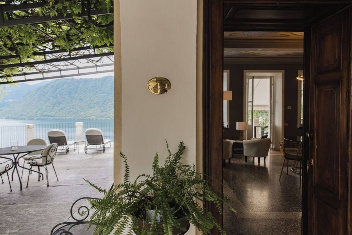A hotel lobby with a view of a mountain and a balcony with outdoor seating.