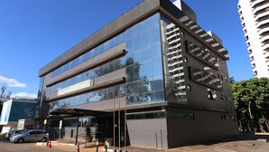 Un hôtel moderne doté d’une façade en verre, de plusieurs étages et d’une entrée bien visible.