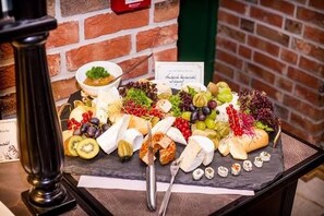 En skiferteplade med et udvalg af oste, frugt og nødder.
