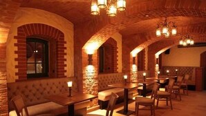 Un restaurante con arcos de ladrillo, cabinas acolchadas y mesas de madera.