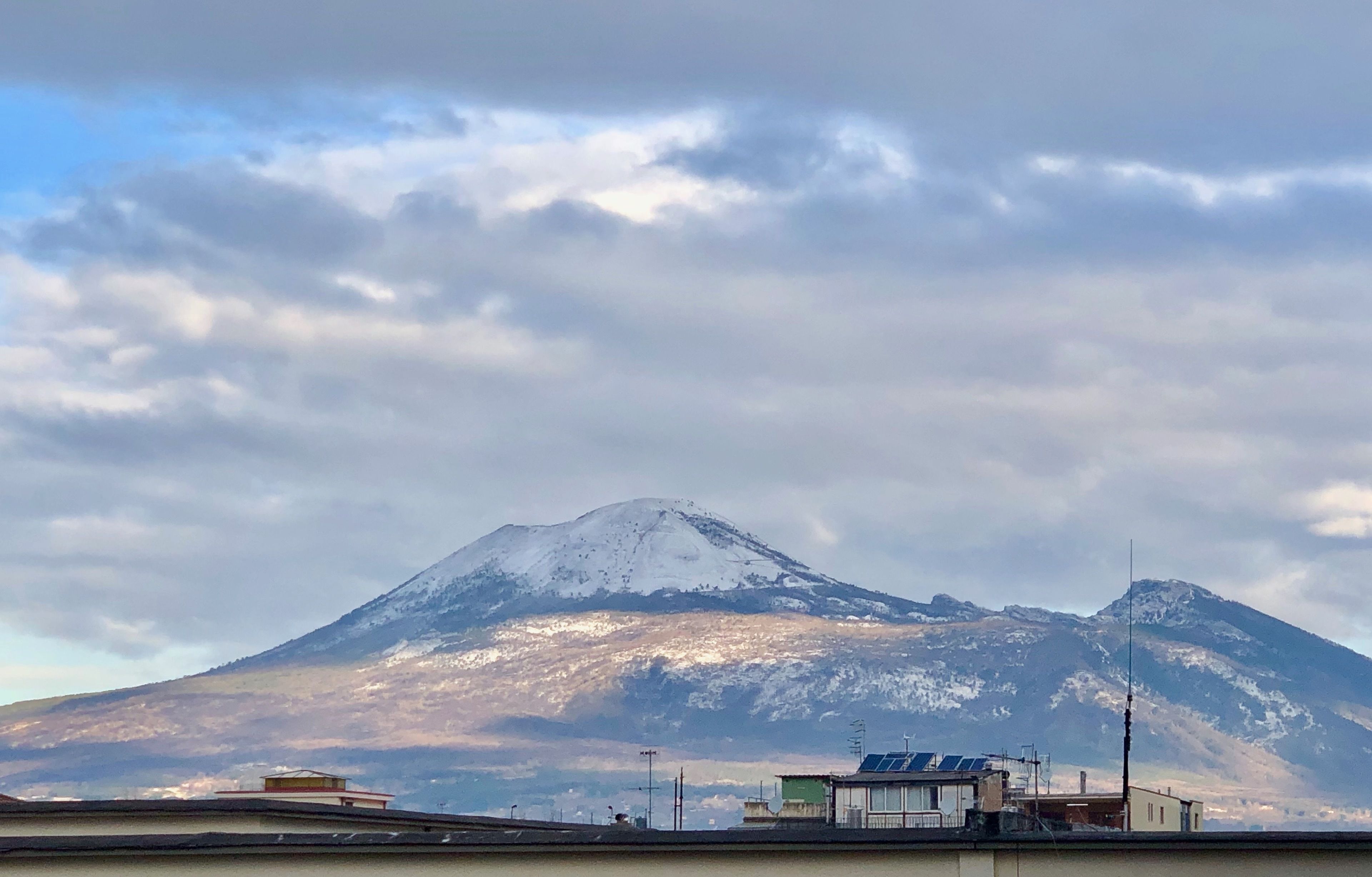 A snow-capped mountain with a clear sky and a few clouds.