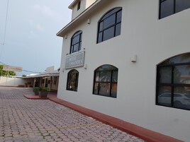 A building with a sign reading "Hotel Lossandes" and a paved entrance.