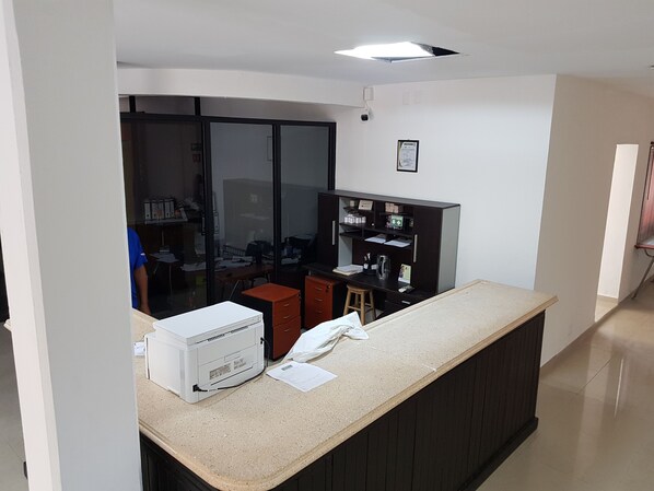 Uma cozinha com geladeira, cafeteira e bancada.