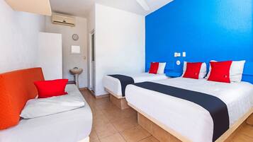 A hotel room with two beds, a sink, and a ceiling fan.