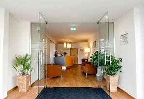 Un'area reception con scrivania, posti a sedere e piante in vaso.