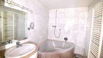 Un bagno con lavandino, specchio e vasca.