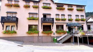 A pink building with multiple balconies, a staircase leading to the entrance, and a sign reading "GASTHOF-PENSION". - Gasthaus Linde (Eberbach)