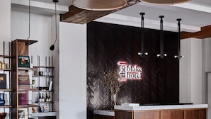 Un moderno vestíbulo de hotel con un sofá rojo, una mesa de centro y un mostrador de recepción.