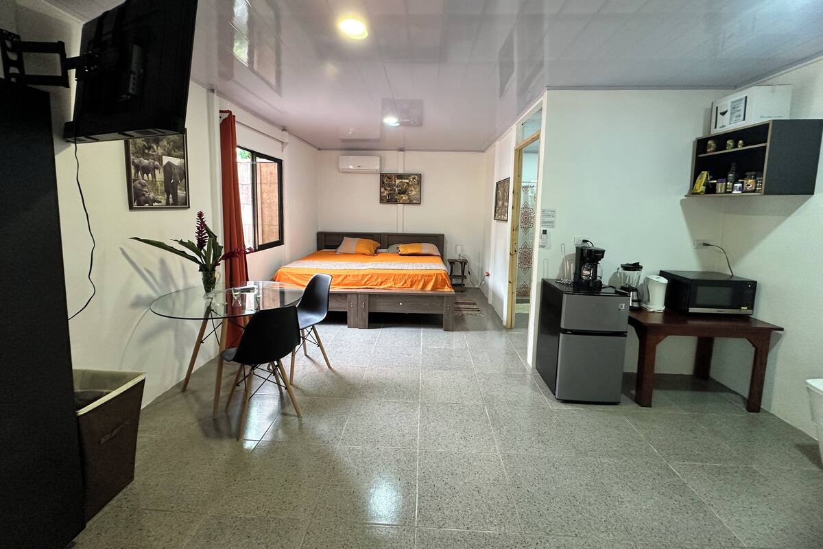 A bedroom with a bed, bedside table, and a desk with a chair.