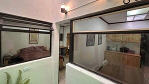 A narrow corridor with a bed on the left and a kitchen area on the right.