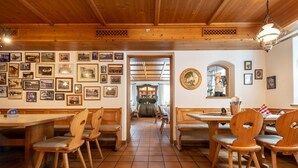 Un restaurante con muebles de madera, pisos de baldosas y paredes decoradas con fotografías enmarcadas.